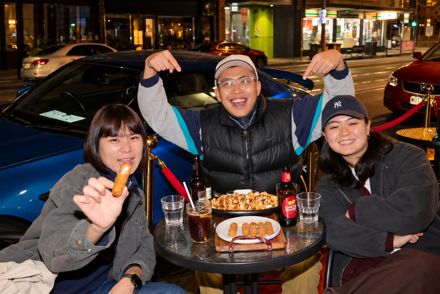 Three guests sharing food and drinks at Illumina's outdoor tables